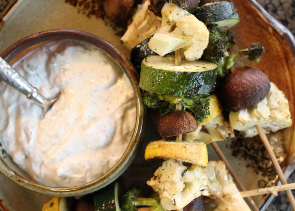 skewers threaded with zucchini, summer squash, mushrooms, cauliflower, and broccoli. Seasoned with a sprinkle of salt and thyme with a bowl of horseradish creamy dip.