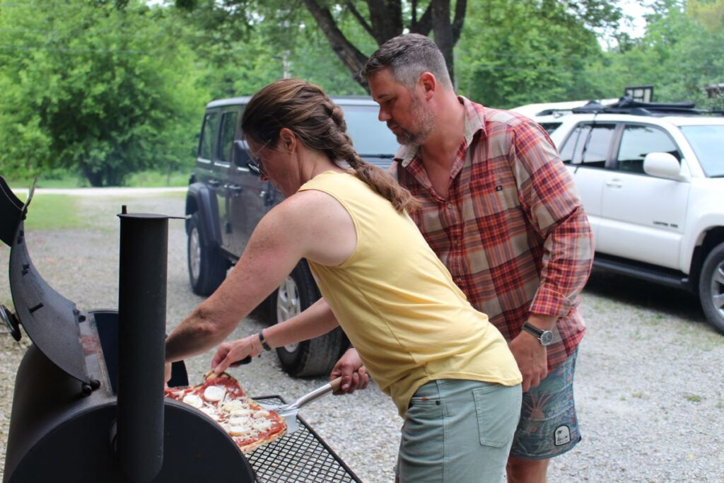 Having a friend help out with grilling pizza. This is Chad and I working together to get pizza off the grill.
