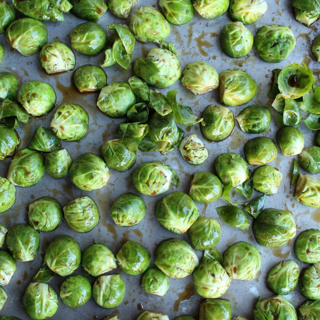 Marinated Brussels sprouts on a pan, cut side down.