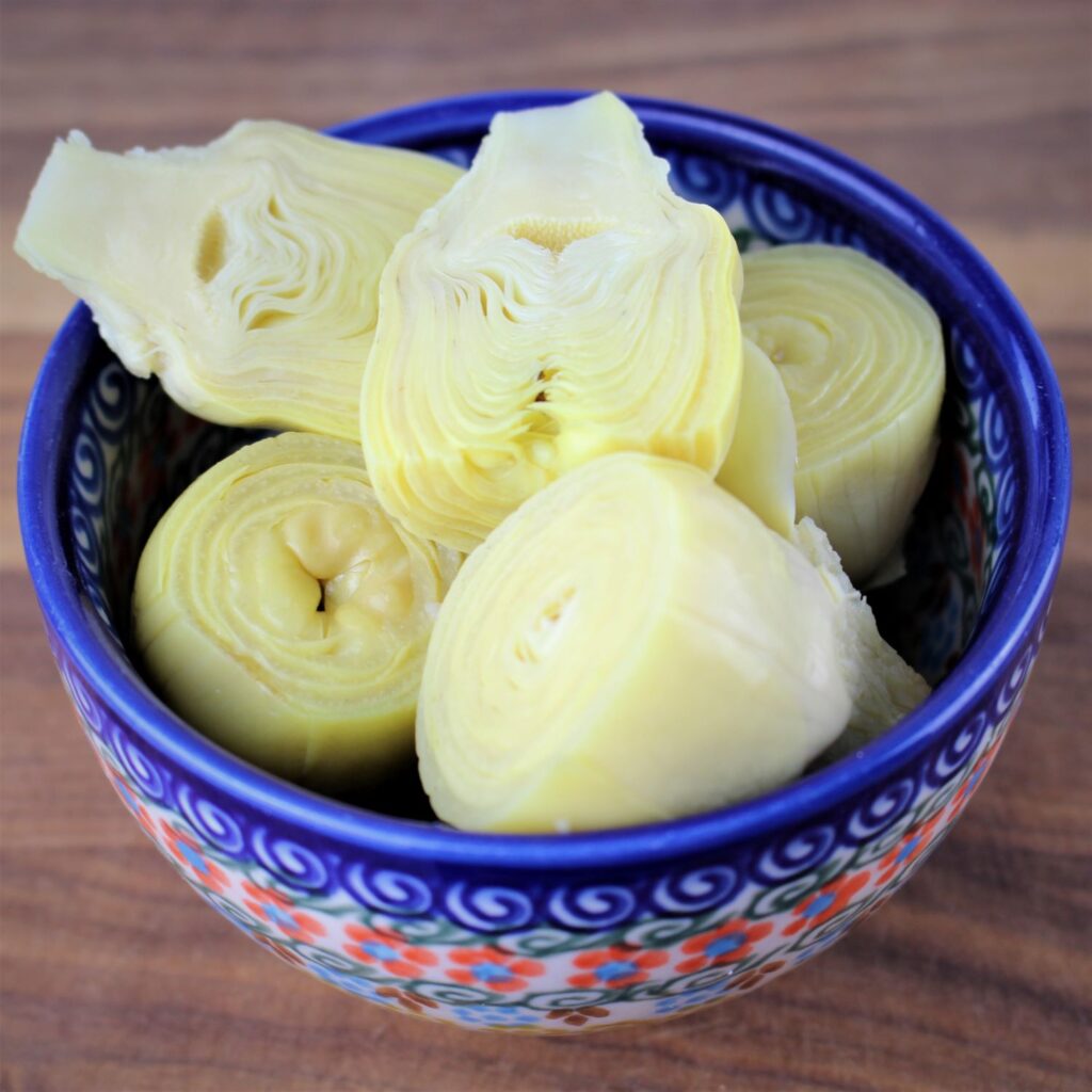 Whole and halved artichoked in a Polish pottery bowl