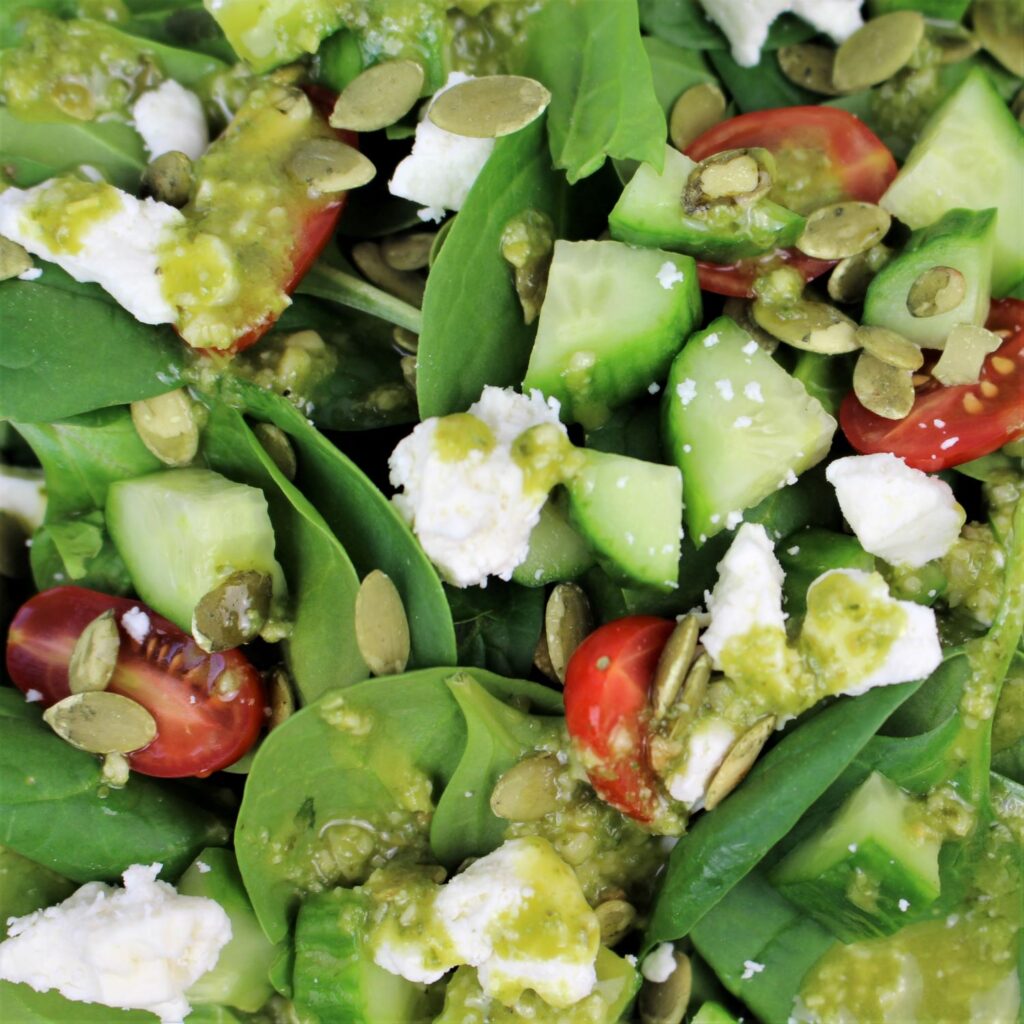 Spinach, cherry tomatoes, cucumbers, olives, goat cheese, and pumpkin seeds make this salad a favorite.