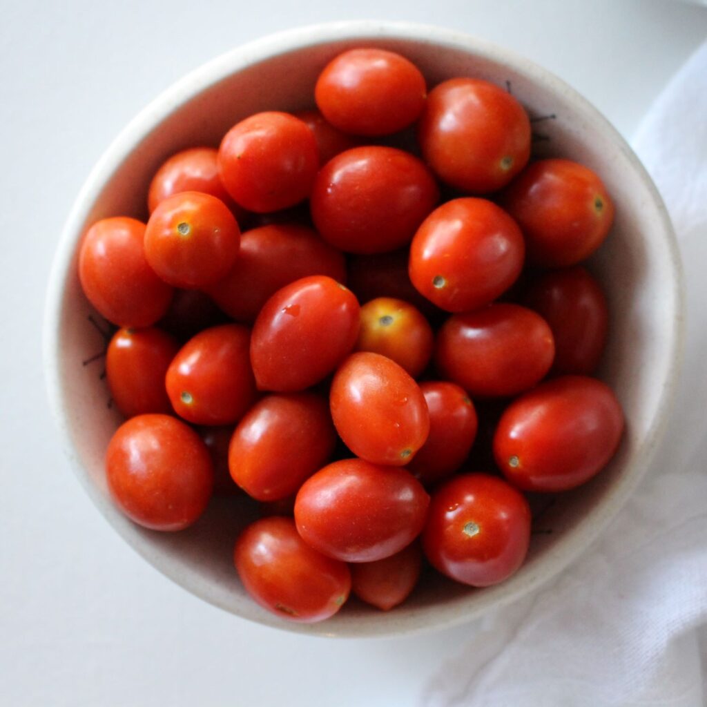 cherry tomatoes in a bowl ready to be mixed in to this shrimp pasta dish.