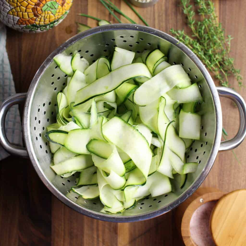 zucchini ribbons in colander with salt to release the water.