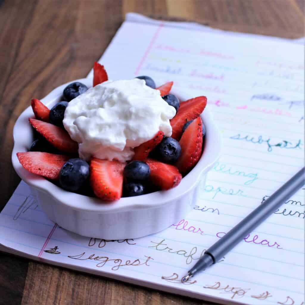 Fresh strawberries and blueberries with a dollop of whipped cream on top