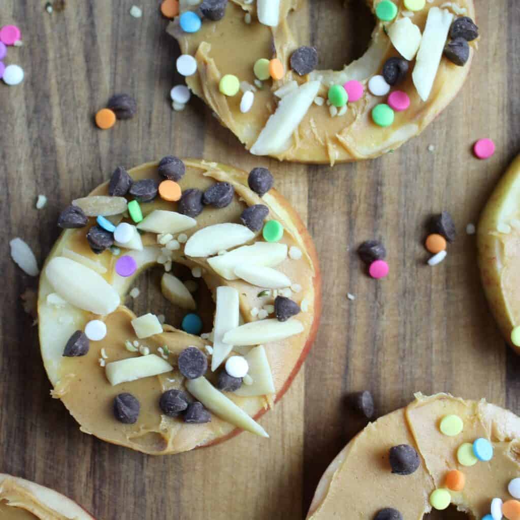 apple ring with peanut butter, and almond slivers, mini chocolate chips, hemp seeds, and sprinkles