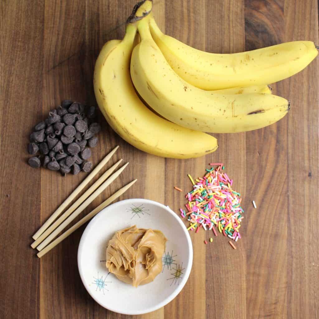 ingredients needed for banana pops: bananas, peanut butter, chocolate for melting, and toppings