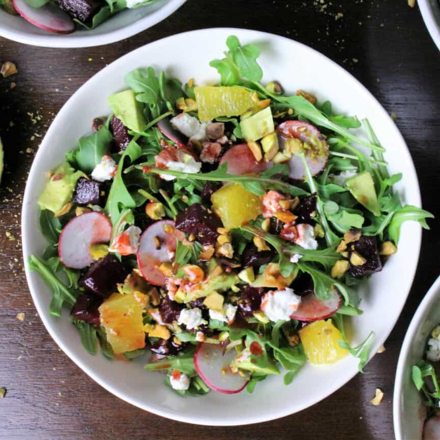 colorful beets, oranges, arugula, avocado, goat cheese, radishes and pistachios all mixed together for a delightful salad.