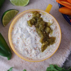 healthy queso dip with 505 southwestern green chili salsa on top.