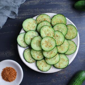Cucumber sliced thin with a sprinkling of tajin, a tangy spice blend of chili peppers, lime, and salt.