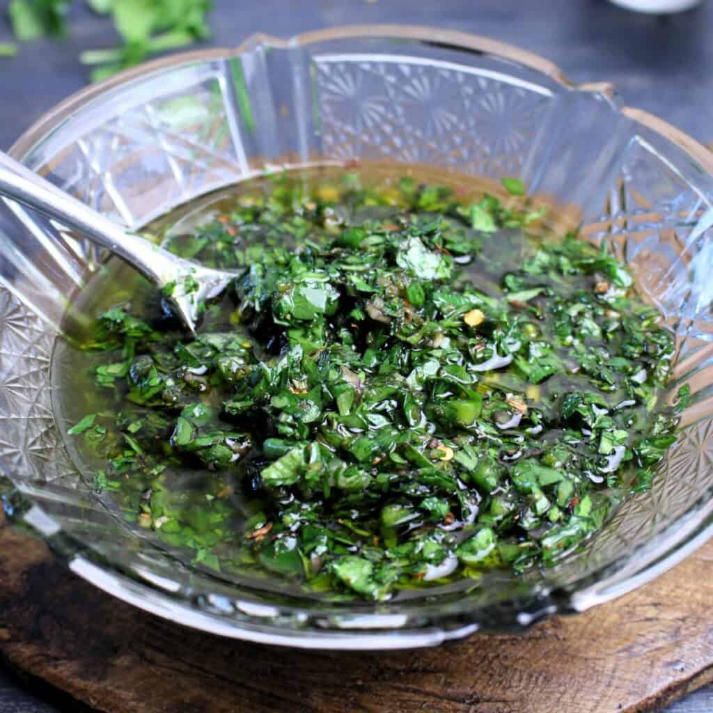 Herby Chimichurri in glass bowl all stirred together and ready to be enjoyed.