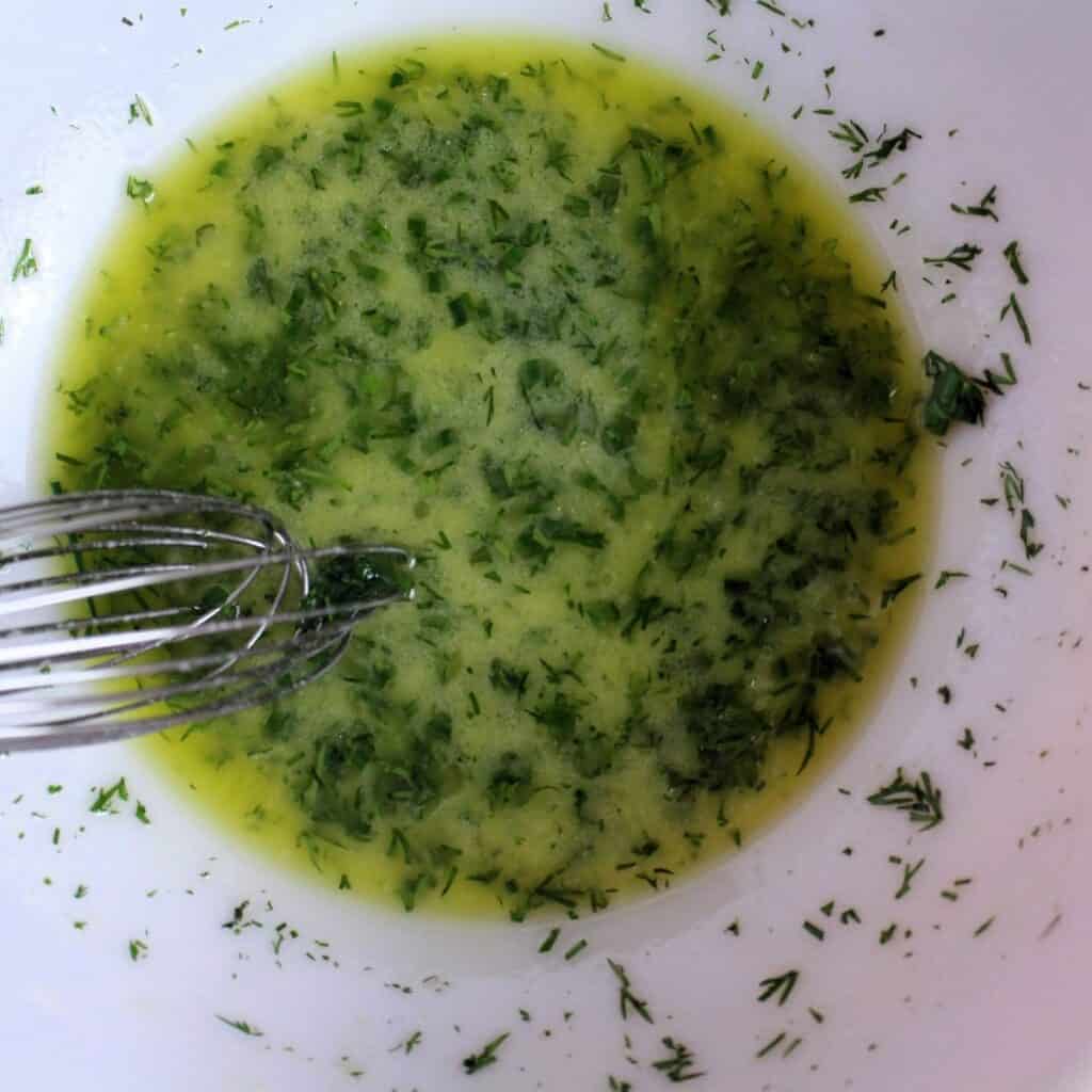 Lemon juice, olive oil, dill, chives & dijon whisked up in a bowl.