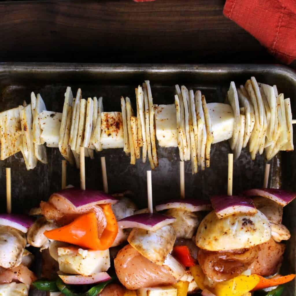 Skewer loaded with cut tortillas and bread cheese, a cheese that can withstand the heat of the grill.