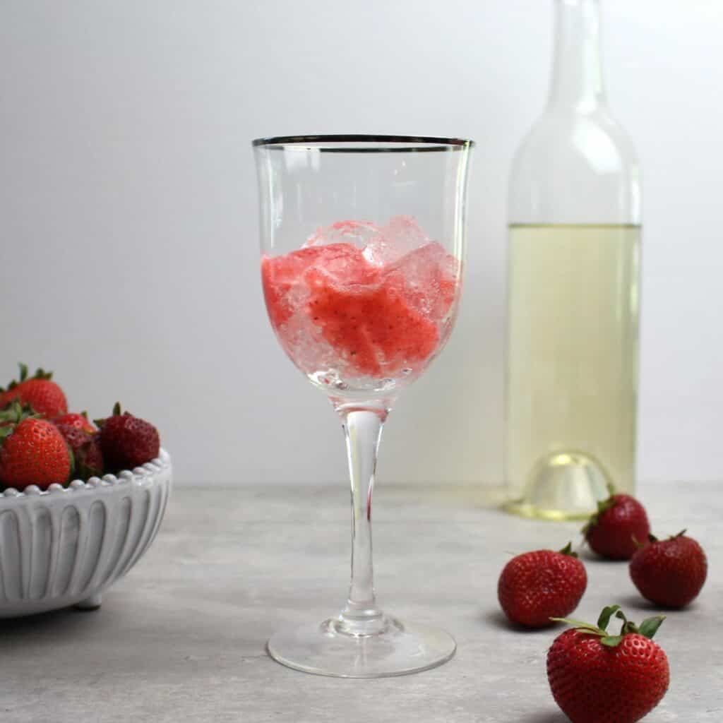 Wine glass with ice and strawberry puree.