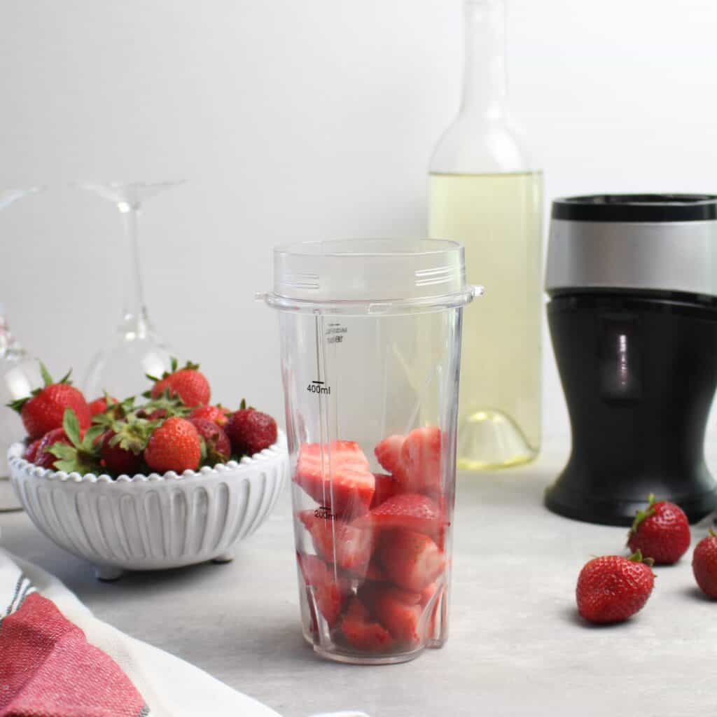 Cut up strawberries in blender.