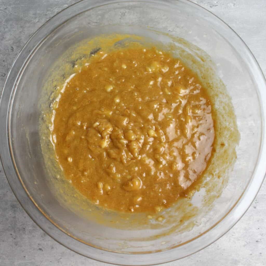 Whisked wet ingredients include mashed bananas, coconut oil, maple syrup, peanut butter, and vanilla.