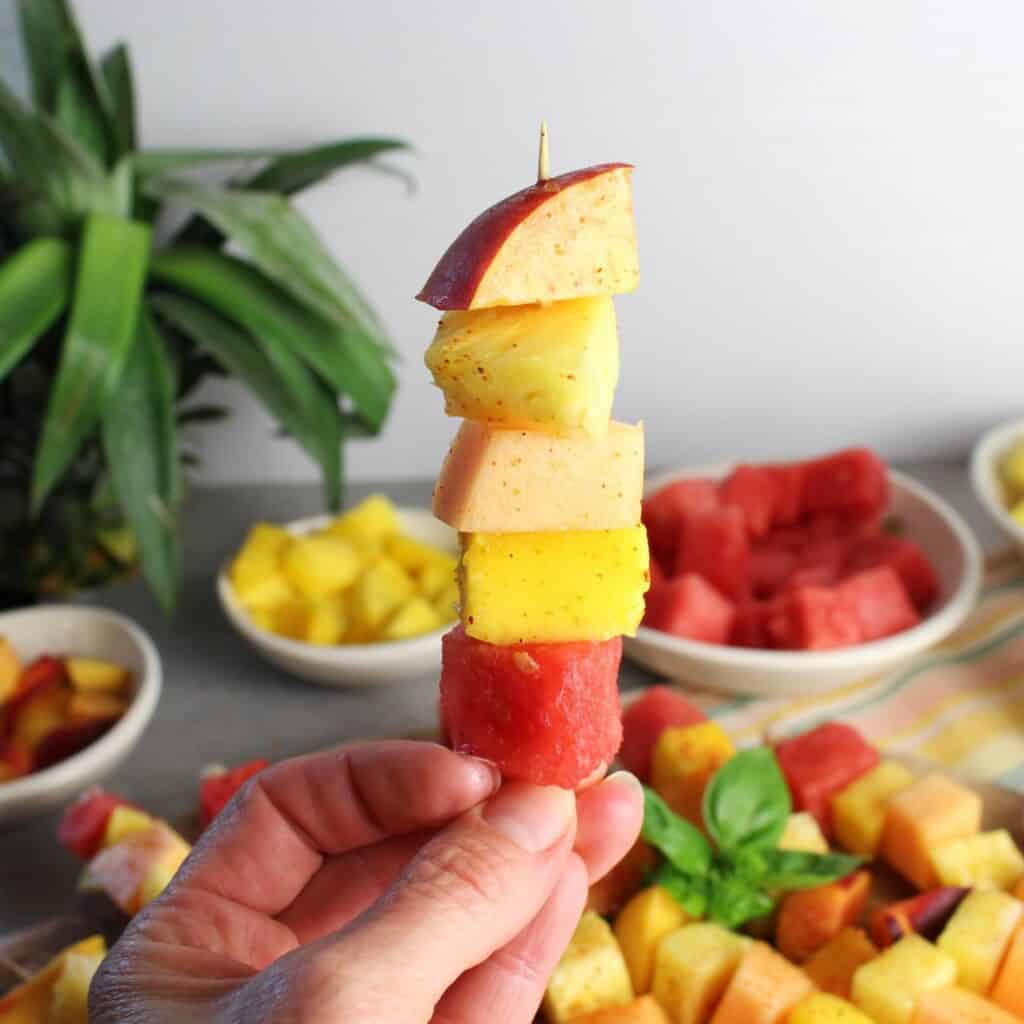 Fruit on a skewer: watermelon, cantaloupe, pineapple, mango, and peaches with a sprinkle of tajin.