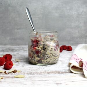 Overnight Oats with Raspberries in glass mason jar ready to eat.