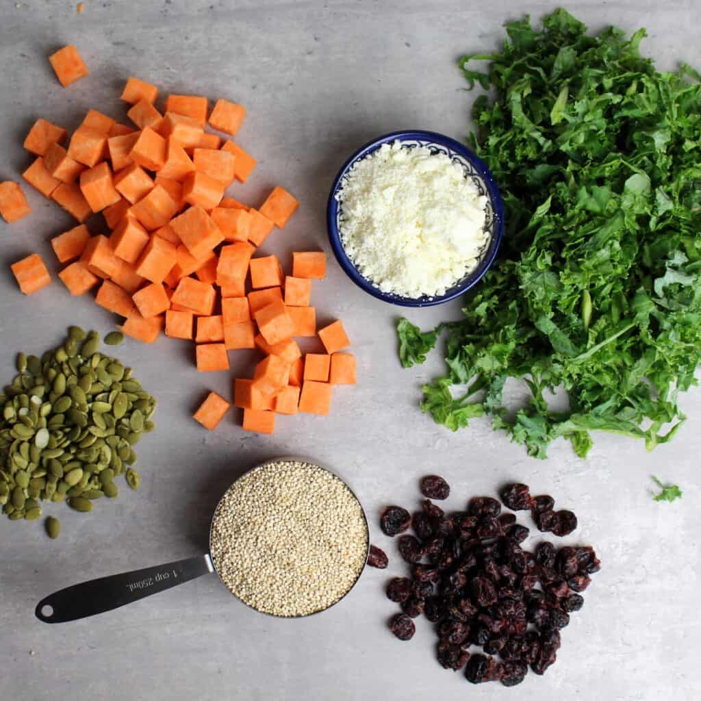 Ingredients for this autumn salad are quinoa, sweet potatoes, kale, dried cranberries, feta, pumpkin seeds.