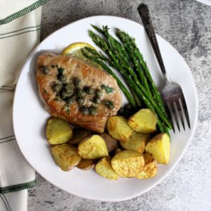 Pork piccata plates with roasted potatoes and asparagus.