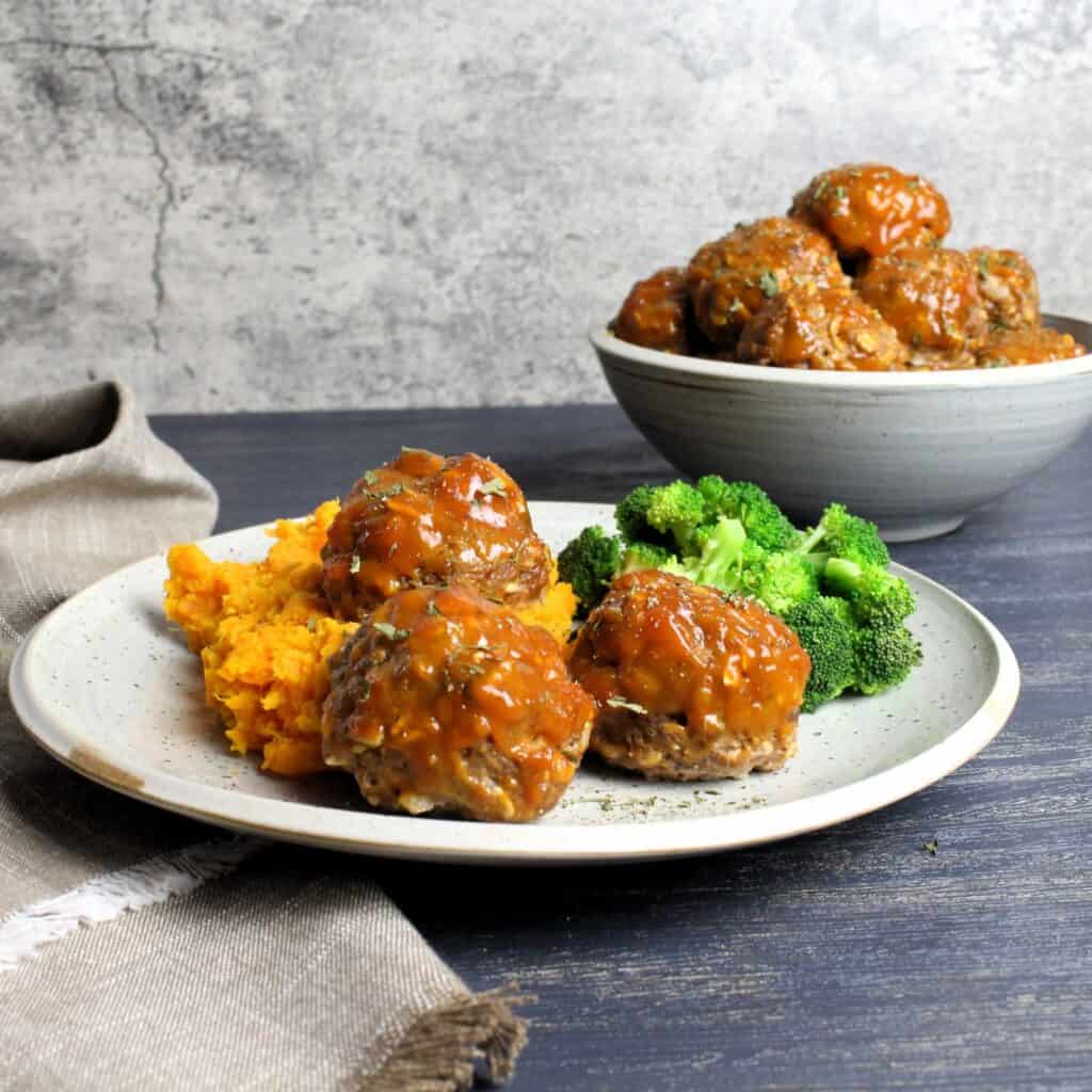 Meatloaf meatballs plated with mashed sweet potatoes, and broccoli.