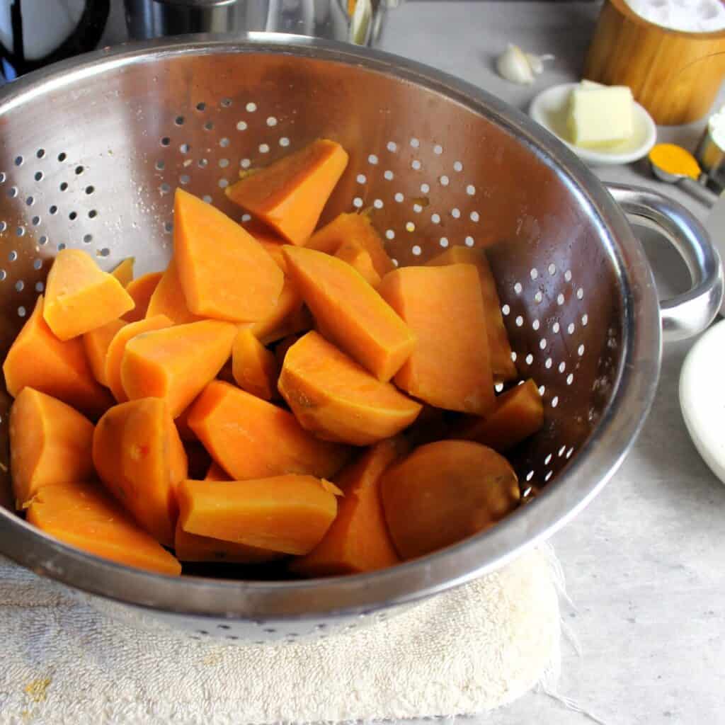 Sweet potato chunks draining in colander.