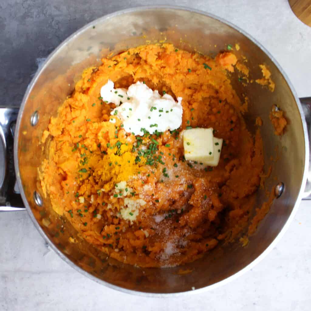 Mashed sweet potatoes with Greek yogurt, butter, turmeric, salt, and chives added in.