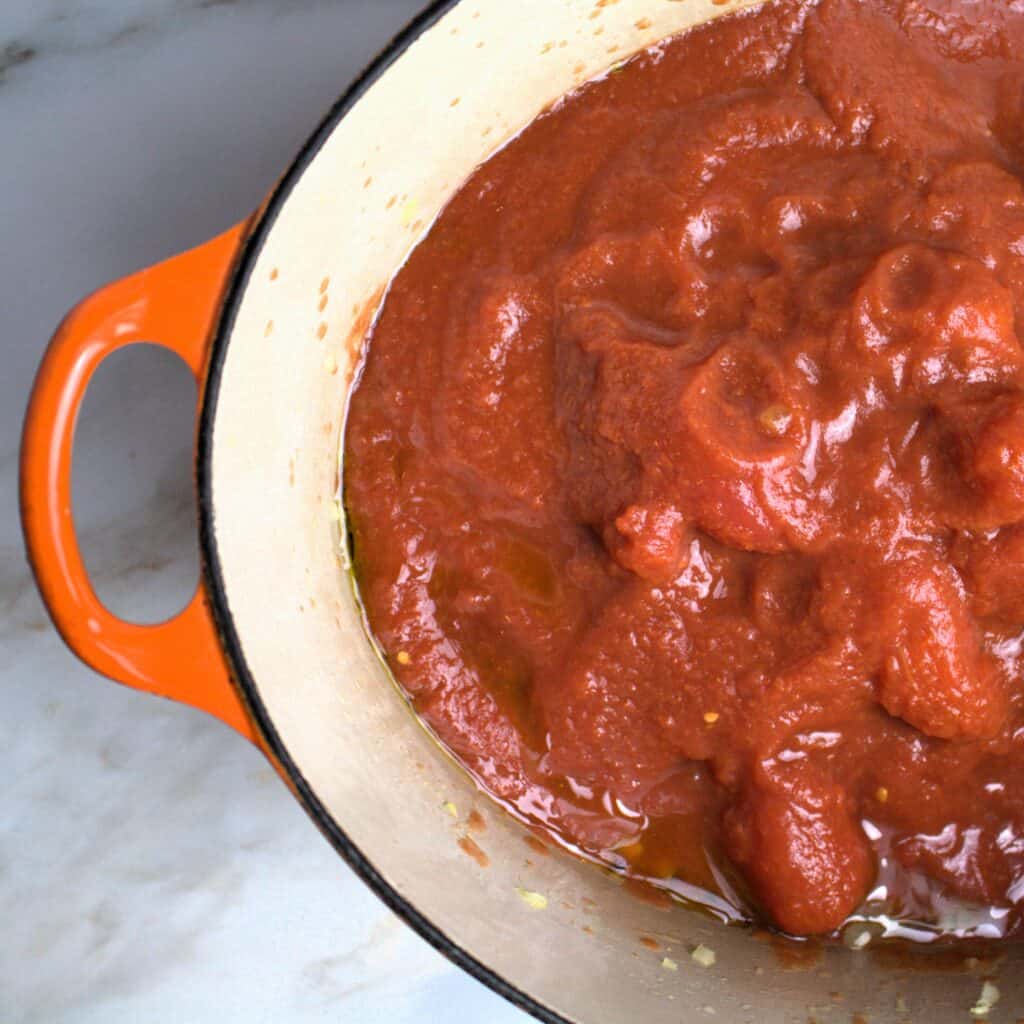 San Marzano tomatoes in pot with onions.