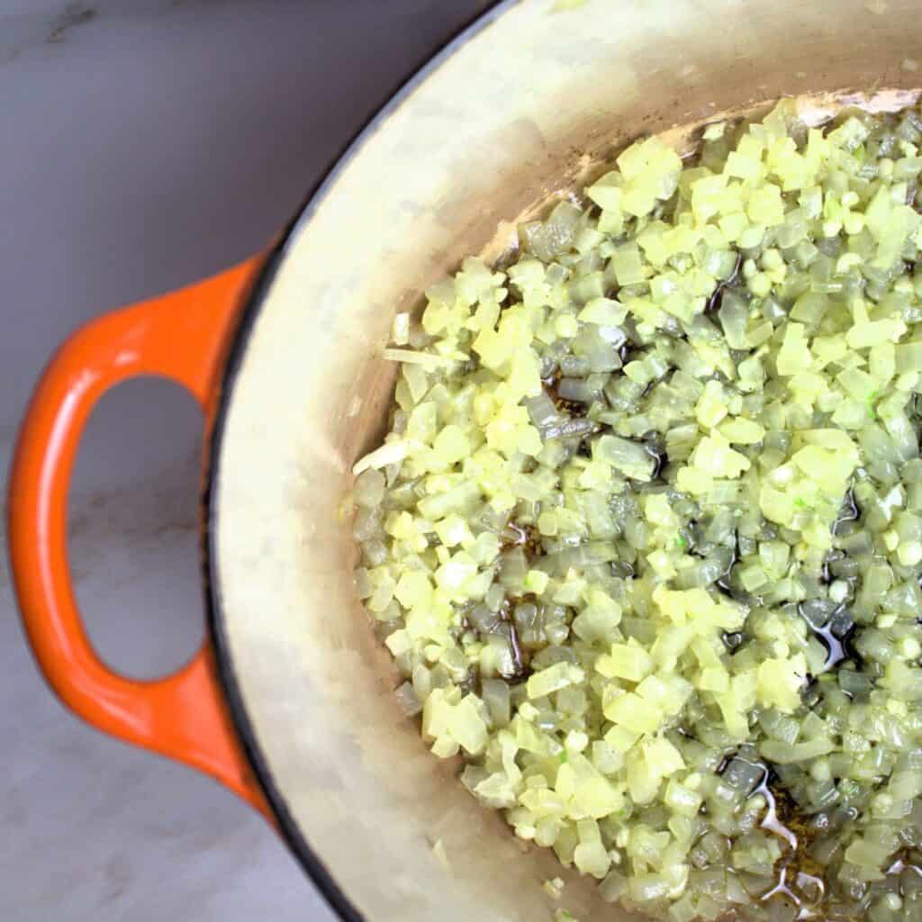 Onions sautéing in enamel coated cast iron pot.